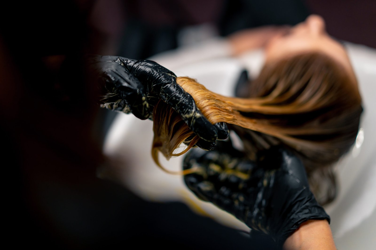 At Skinfinity a specialist expertly applies highlights to a woman's hair to create a stunning transformation.