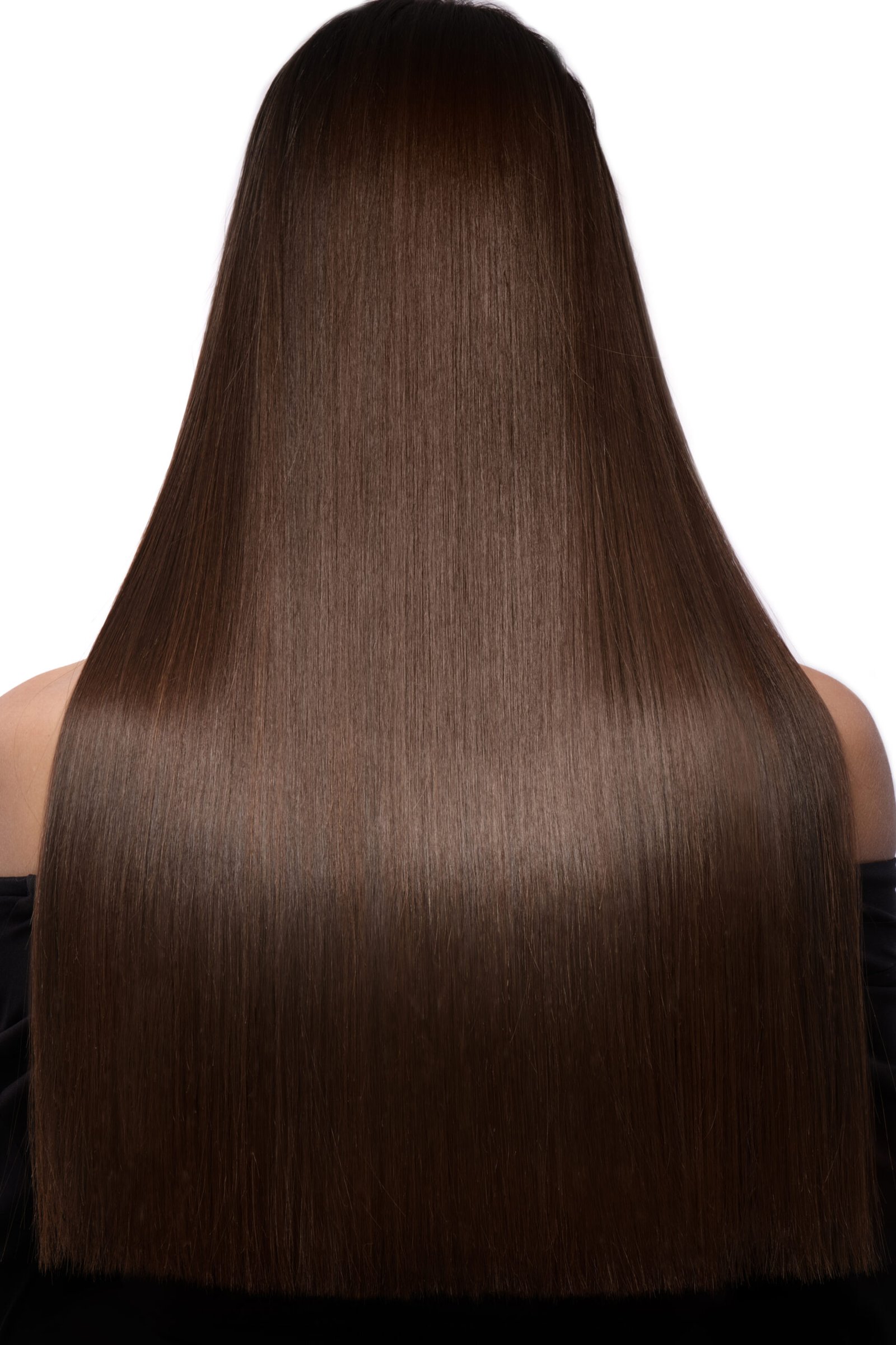 A woman with sleek, smooth hair, shining with a healthy, polished finish, stands with confidence, showcasing the flawless results of a keratin treatment.