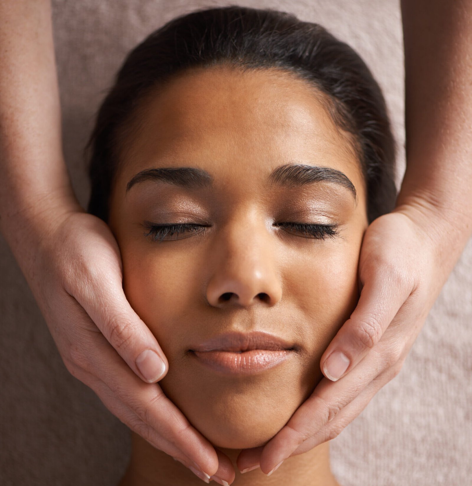 A woman indulges in a getting a luxurious facial massage, radiating tranquility and elegance in a lavish spa setting.