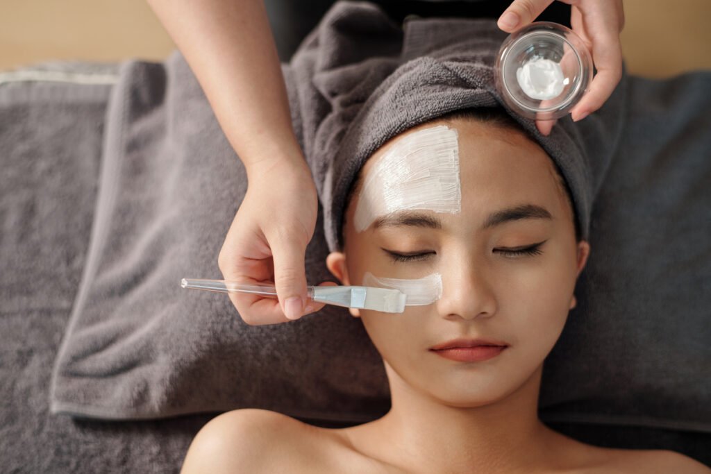 A woman enjoys a rejuvenating facial mask treatment at a serene spa, enhancing her skin's vitality and glow.