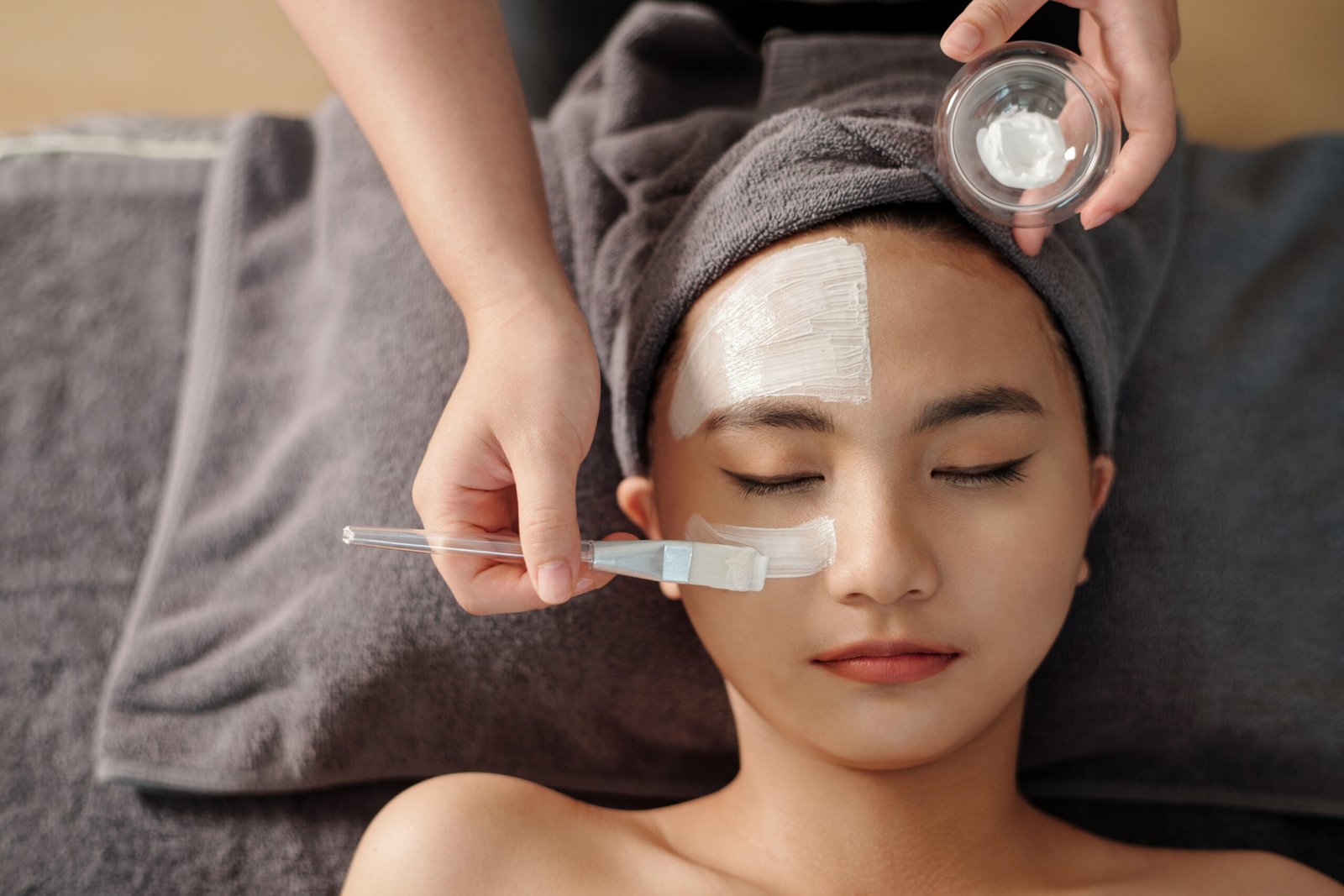 A woman enjoys a rejuvenating facial mask treatment at a serene spa, enhancing her skin's vitality and glow.