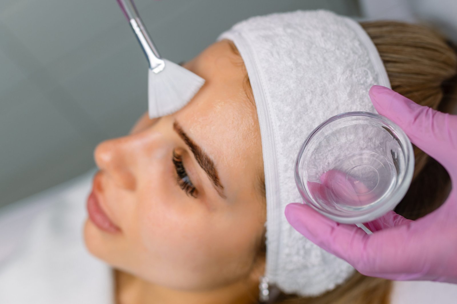 A woman is pampered with a facial treatment in a peaceful spa setting, featuring calming decor and a relaxing atmosphere.