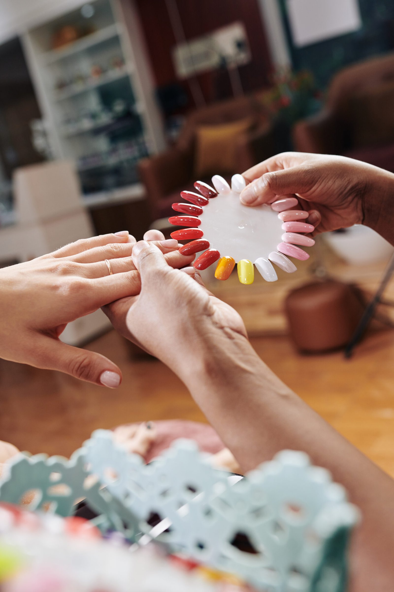 A woman choosing colors for having nail extensions to be applied to at a luxury nail salon .