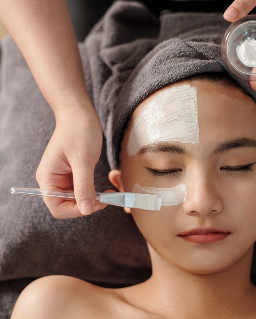 A woman enjoys a rejuvenating facial mask treatment at a serene spa, enhancing her skin's vitality and glow.