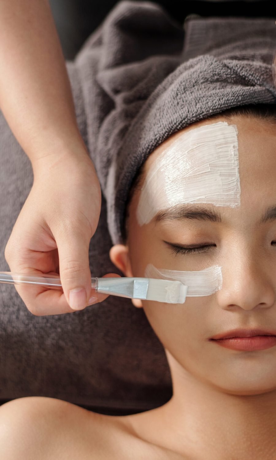 A woman enjoys a rejuvenating facial mask treatment at a serene spa, enhancing her skin's vitality and glow.