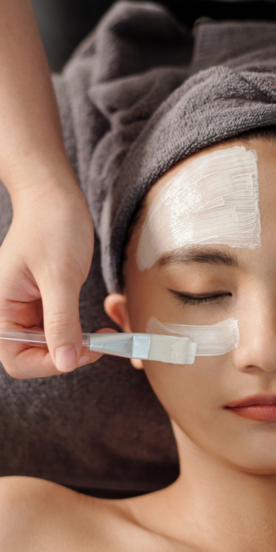 A woman enjoys a rejuvenating facial mask treatment at a serene spa, enhancing her skin's vitality and glow.