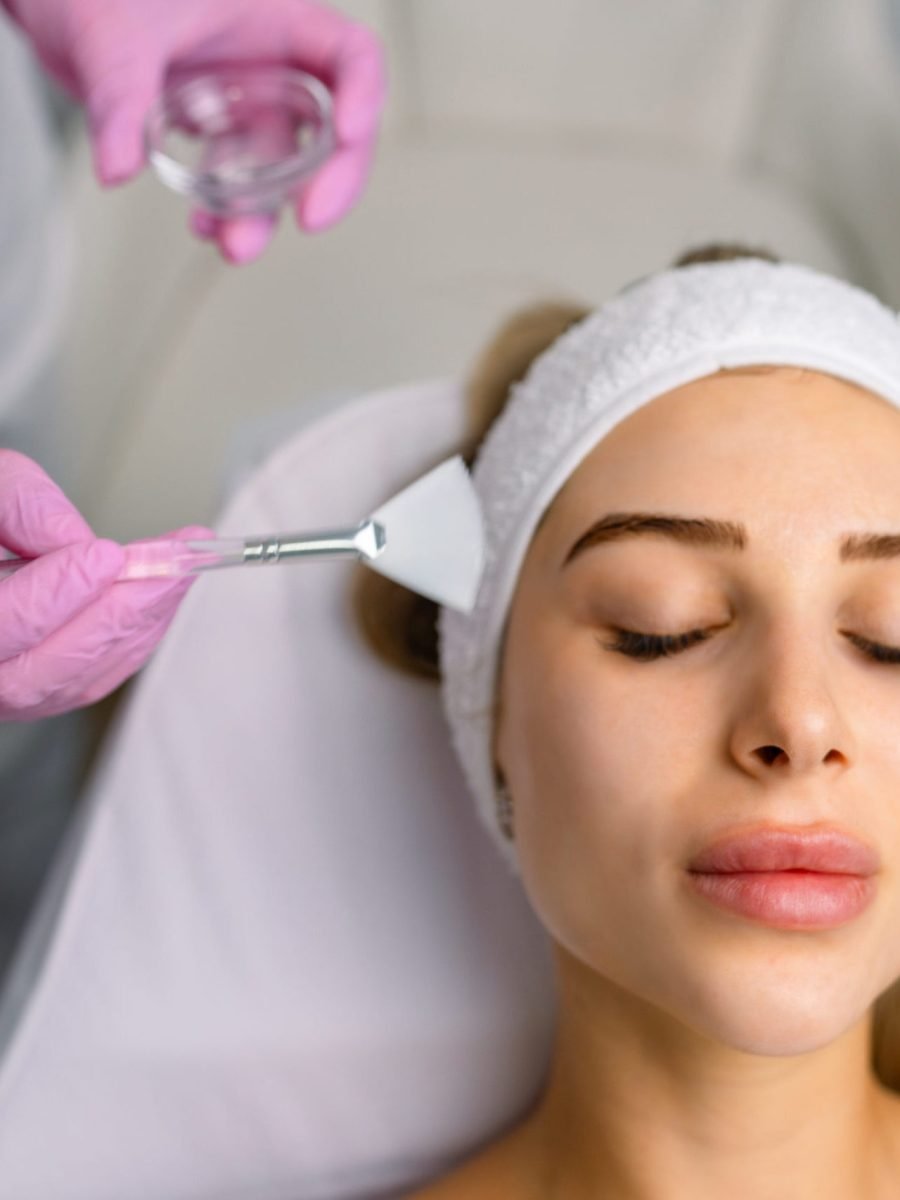 A woman receiving a skin brightening facial treatment in a beauty salon, in a relaxing mood.